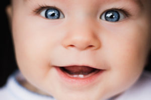 Close up of an adorable baby with two front teeth to demonstrate that your baby should have his or her first dental visit at age one. 