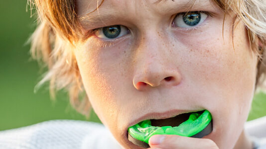 Boy putting in sports mouth guard