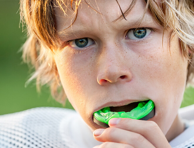 Boy putting in sports mouth guard