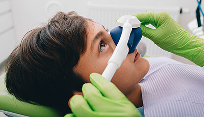 Boy with sedation mask on before dental procedure